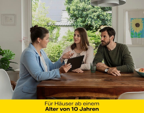 Eine Frau mit einem hellblauen Blazer sitzt gemeinsam mit einem Mann und einer Frau an einem Esstisch. Sie hält ein Tablet in der Hand und erklärt den beiden etwas. Sie befinden sich in einem modernen und hellen Esszimmer.