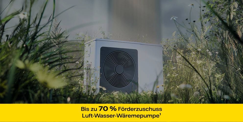 Moderne Wärmepumpe steht auf einer Wiese umringt von vielen verschiedenen Blumen und Gräsern.