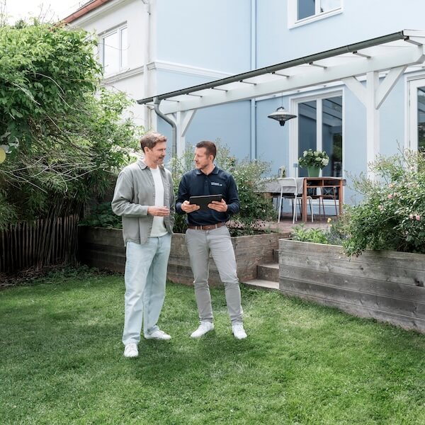 Mann Frau vor Haus mit PV-Anlage