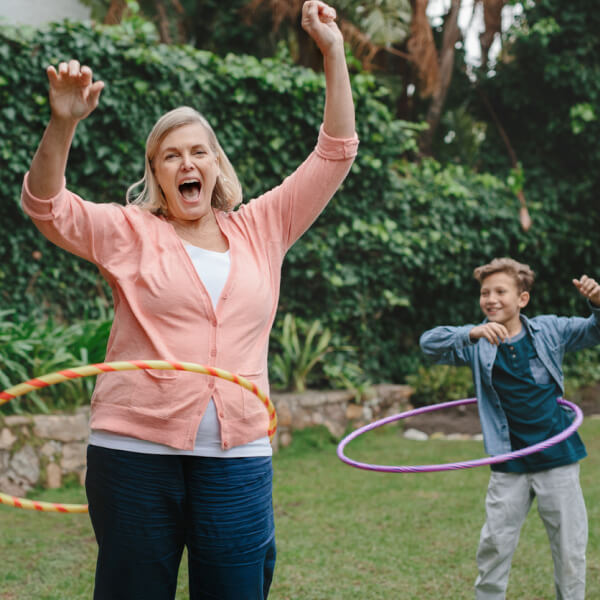 Familie spielt im Garten mit einem Hula Hoop