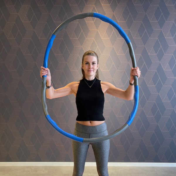Junge Frau trainiert mit dem Hula Hoop Reifen