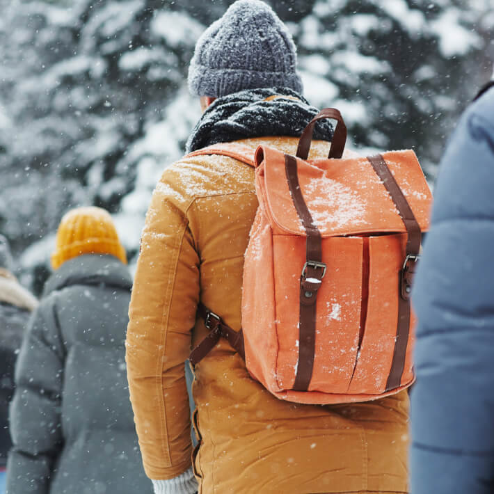 Im Schnee wandernde Person mit Rucksack