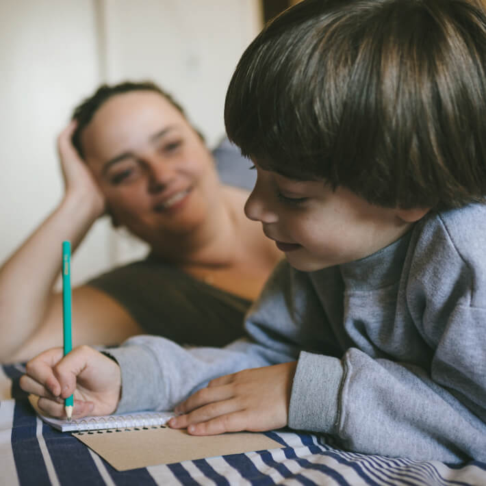 Kind schreibt mit Hilfe der Mutter Tagebuch