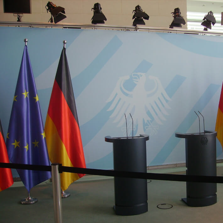 EU und Deutschlandflagge neben Redepult