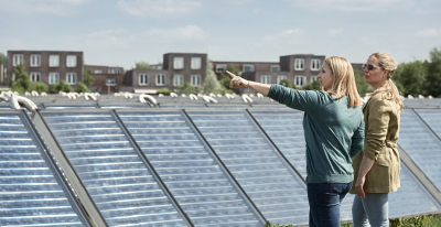 Zwei Frauen stehend vor dem Solarpanel