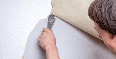 Mann spachtelt Wand mit Zement